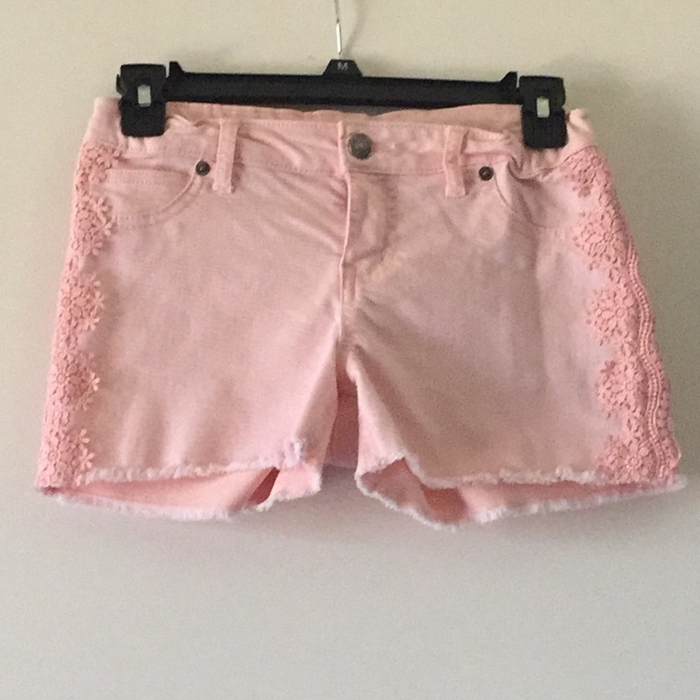 Peach jean shorts with embroidery on the sides